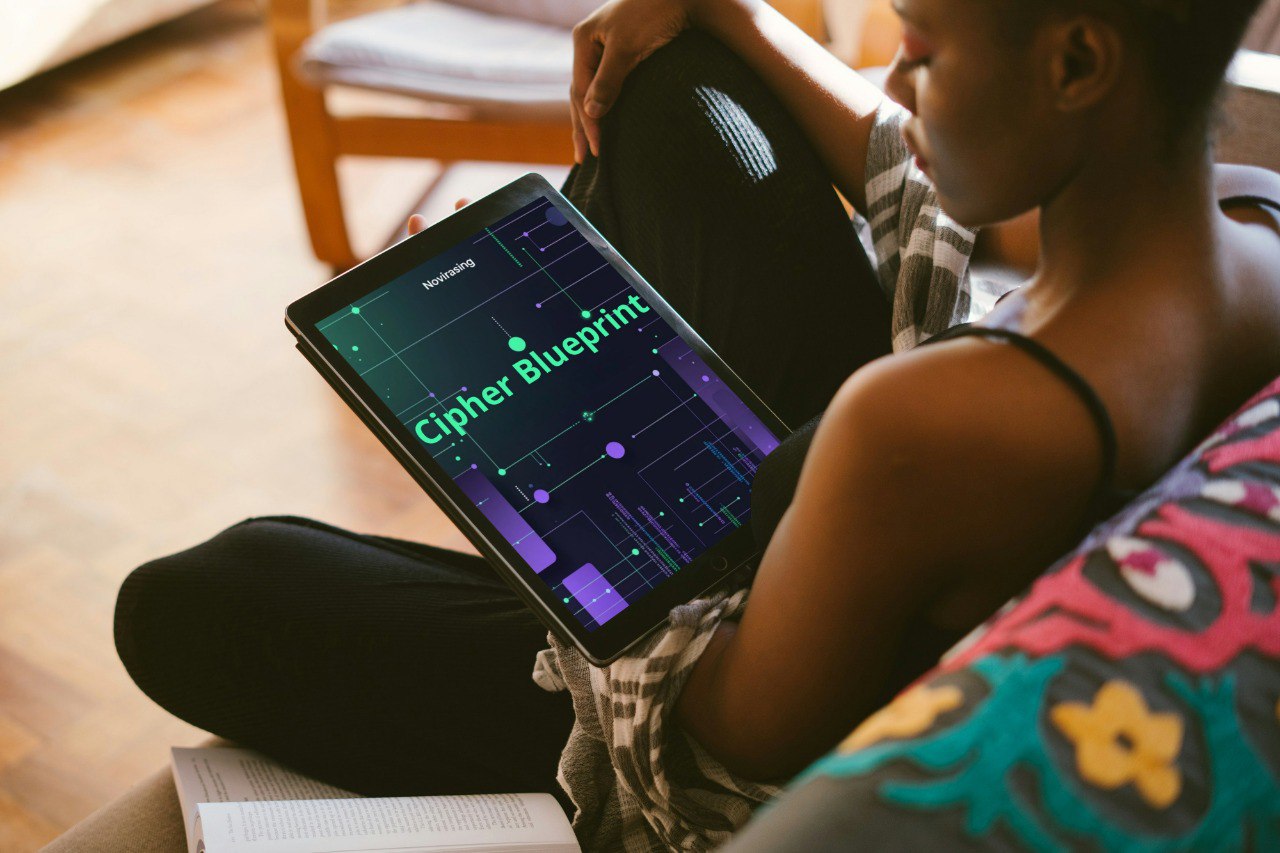 Person holding a tablet with 'Cipher Blueprint' displayed, sitting on a couch.