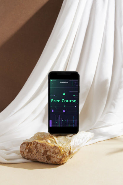 Smartphone displaying 'Free Course' on a stone surface with white fabric in the background